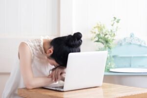 睡魔に襲われて寝落ちする女性